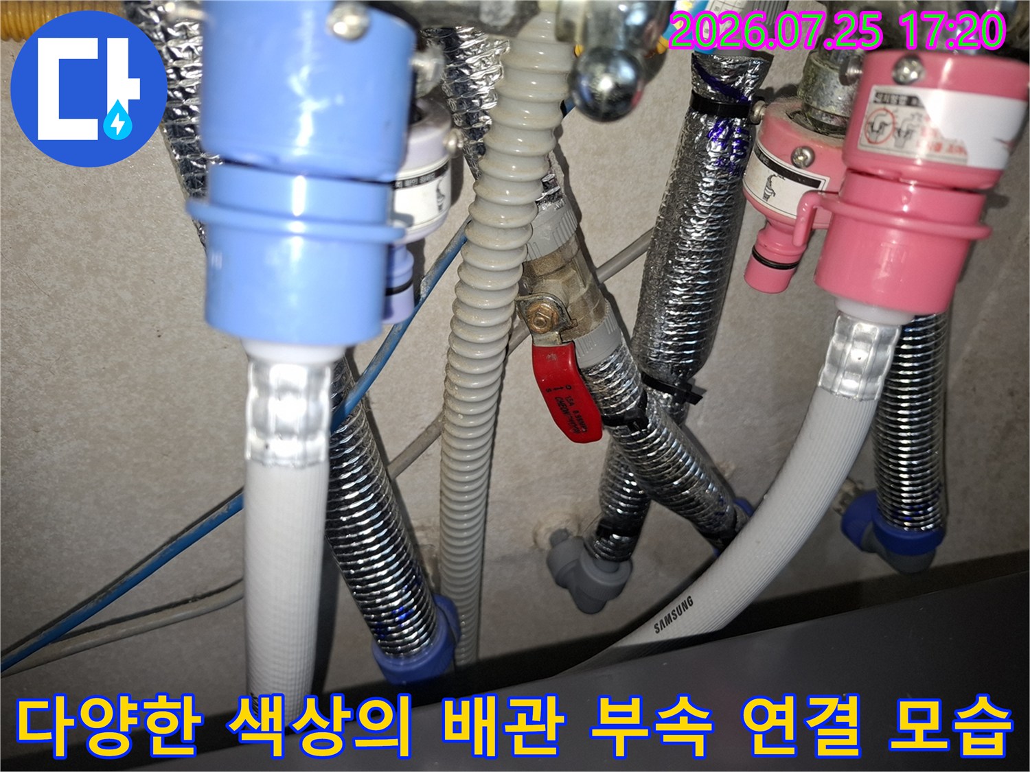파란색과 분홍색 커넥터 및 은색 플렉시블 호스가 복잡하게 얽힌 배관 시스템