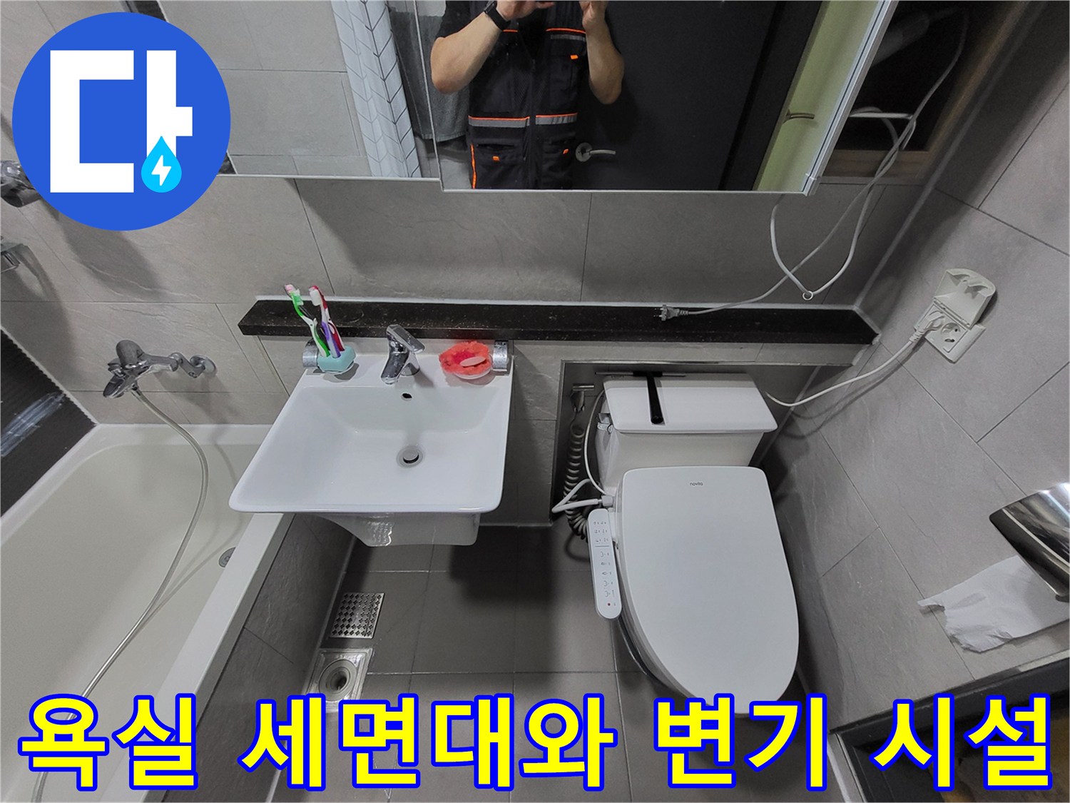 세면대 하단 수전과 변기가 배치된 욕실 내부 전경 사진입니다.