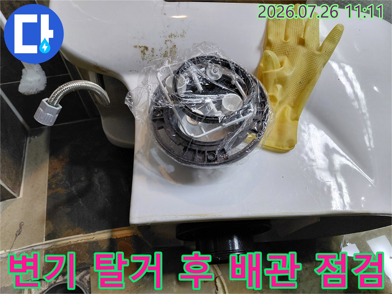 변기를 제거한 공간에 노출된 배수 파이프와 앵글밸브의 세부 구조