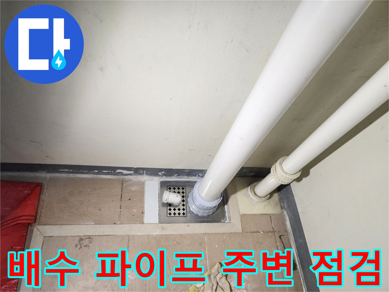 하얀색 배수관과 유가 덮개가 설치된 세탁실 바닥 모습입니다.