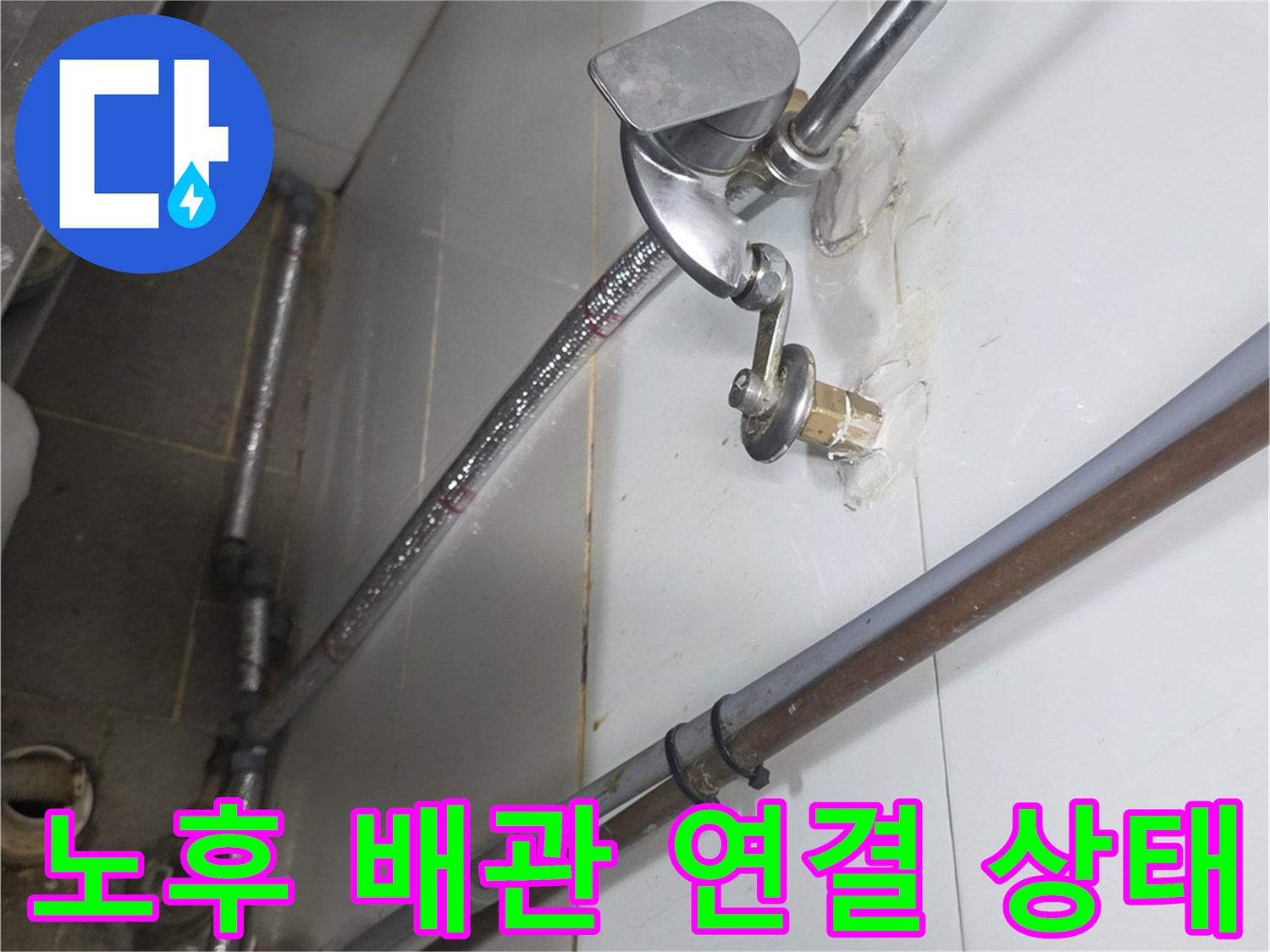 벽면에 고정된 금속 관과 수전의 결합 부위 상세 사진