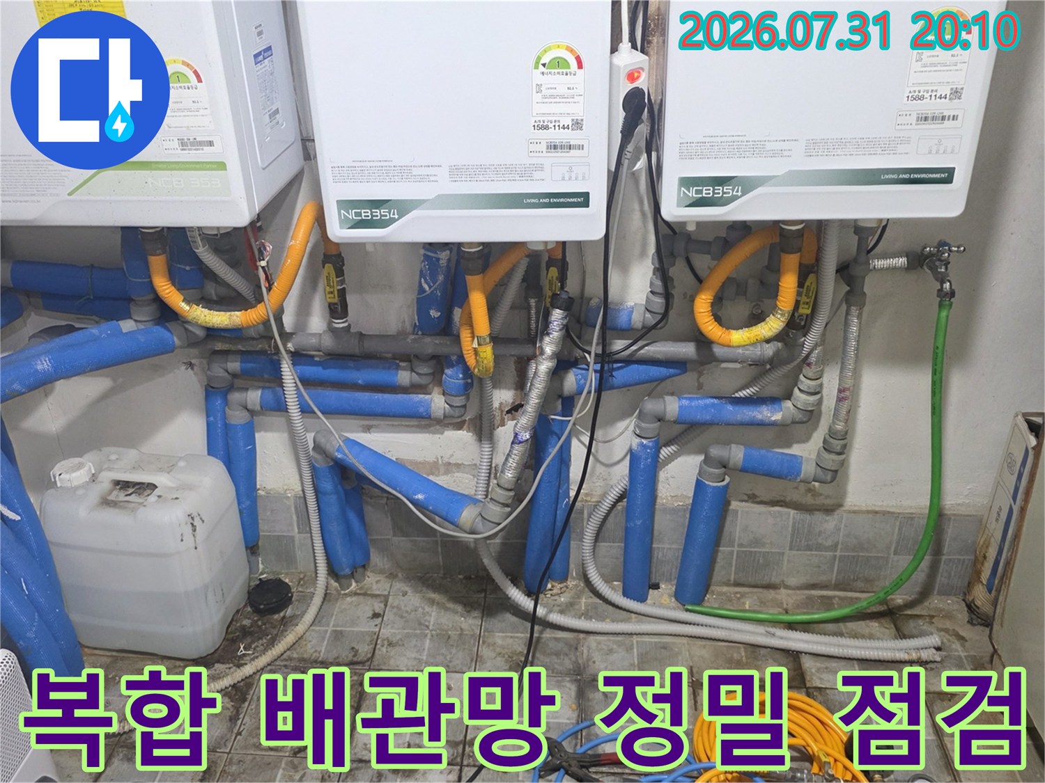 노란색과 파란색 보온재가 섞여 있는 복잡한 수배관들이 모여있는 설비실 내부 모습