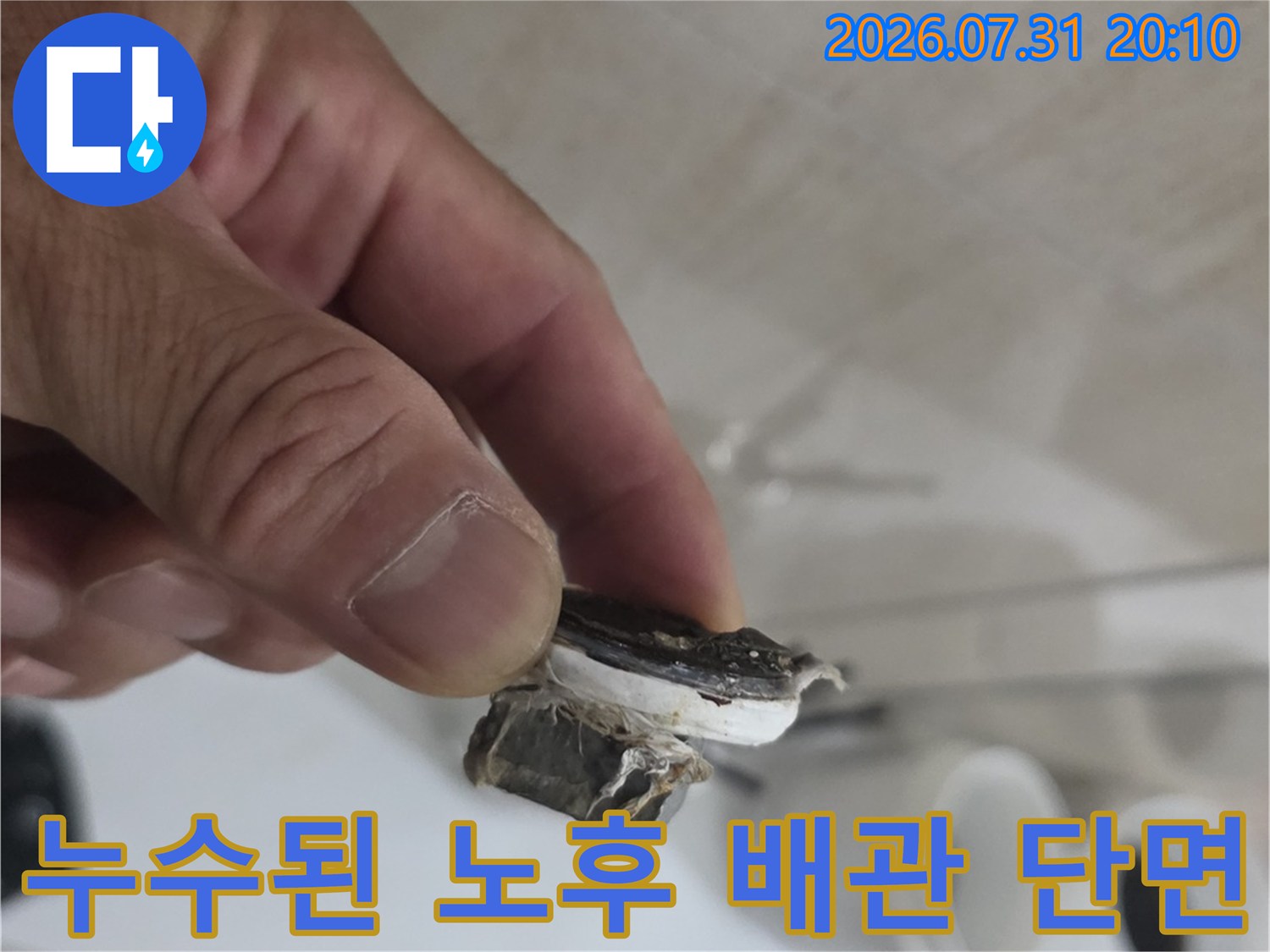 손으로 들고 있는 노후한 배관의 파손 부위 상세 촬영