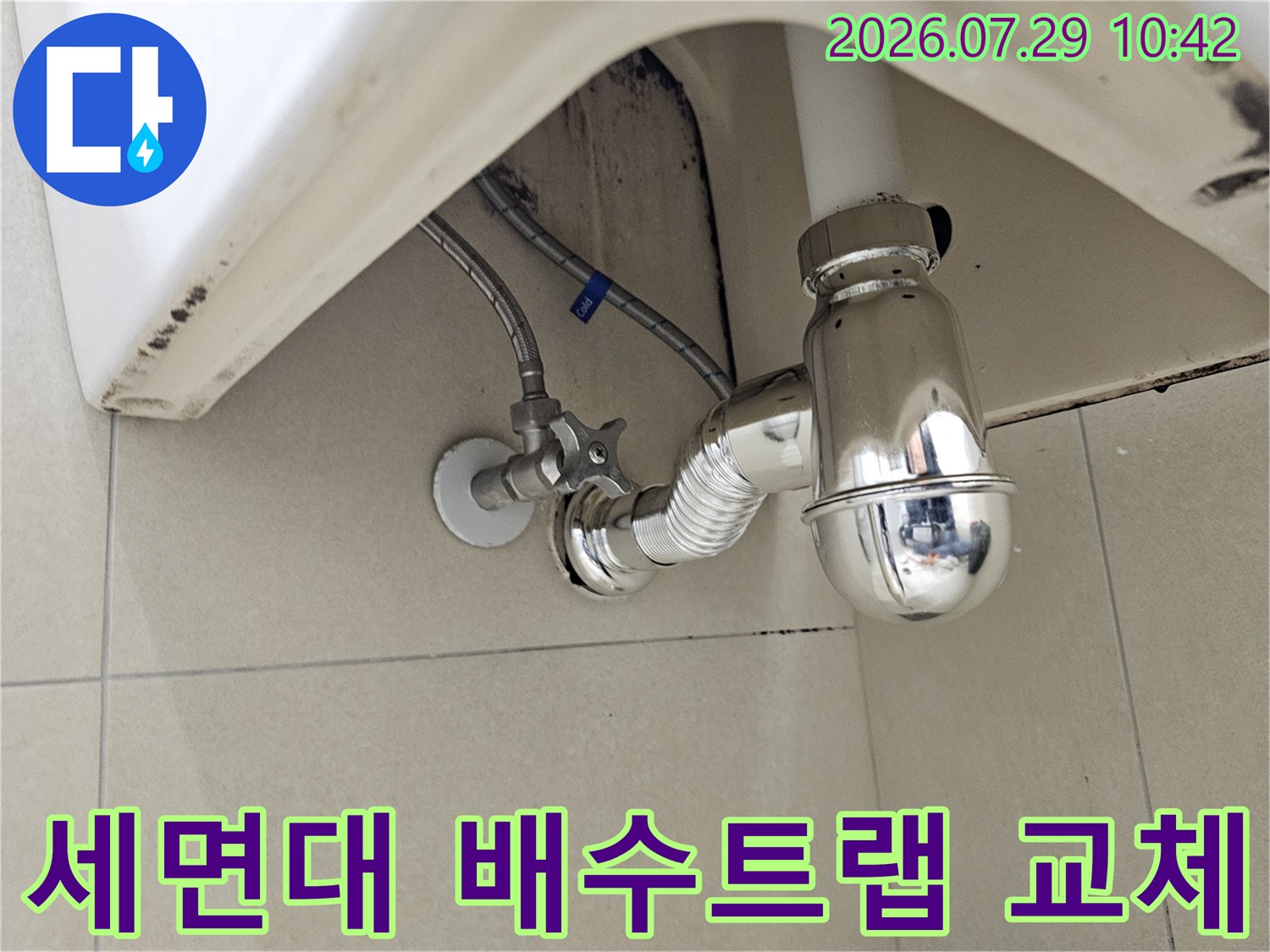 세면대 하단에 설치된 금속 재질의 배수 트랩과 연결 배관 부위