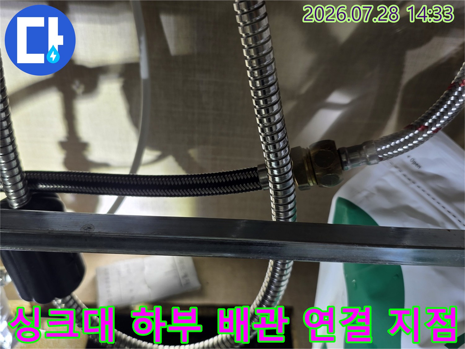 여러 가닥의 스테인리스 주름 호스가 너트로 결합된 싱크대 내부 모습