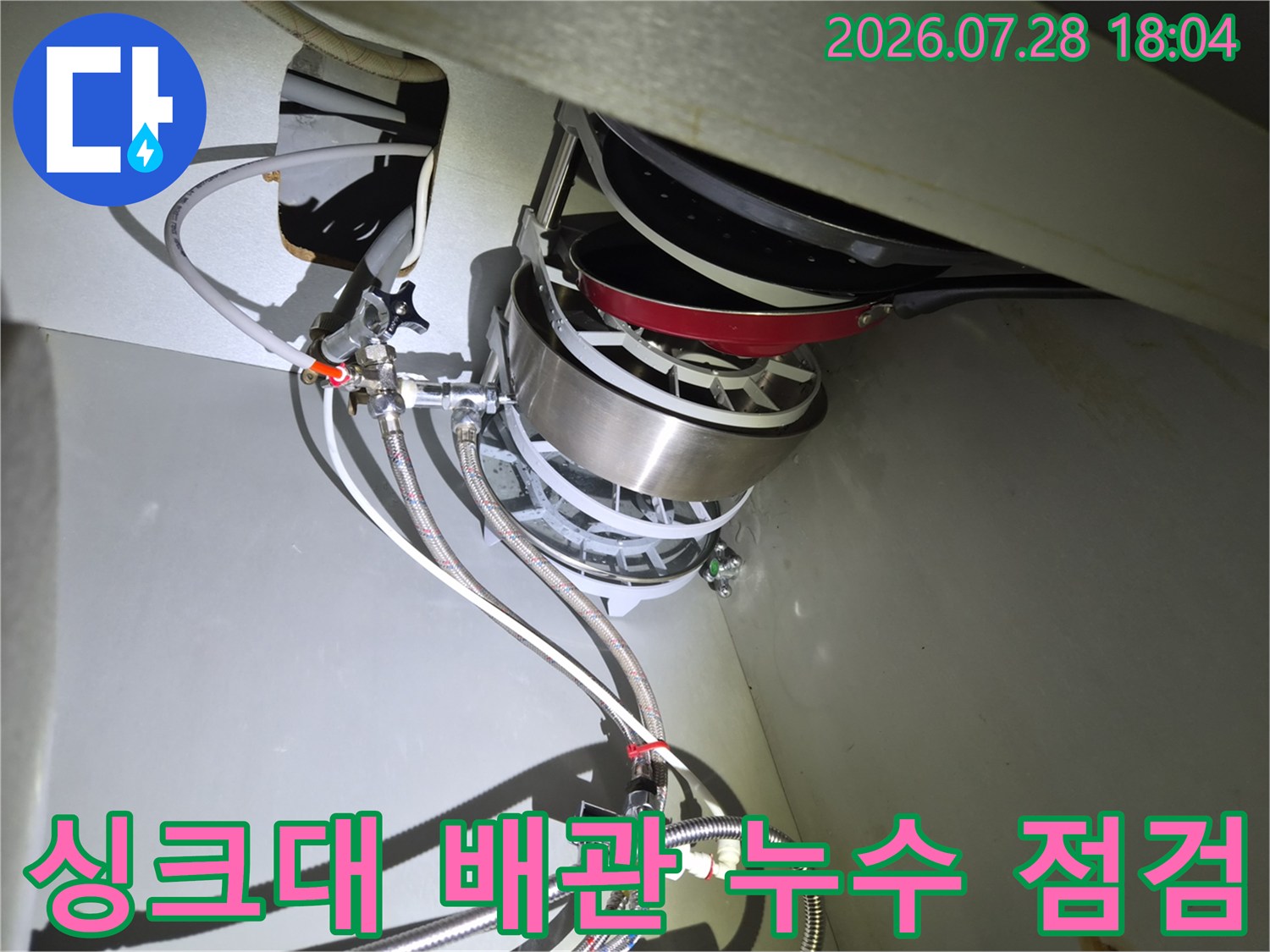 식기세척기 연결 부위의 노출된 배관과 수전 부속을 정밀하게 점검하는 모습