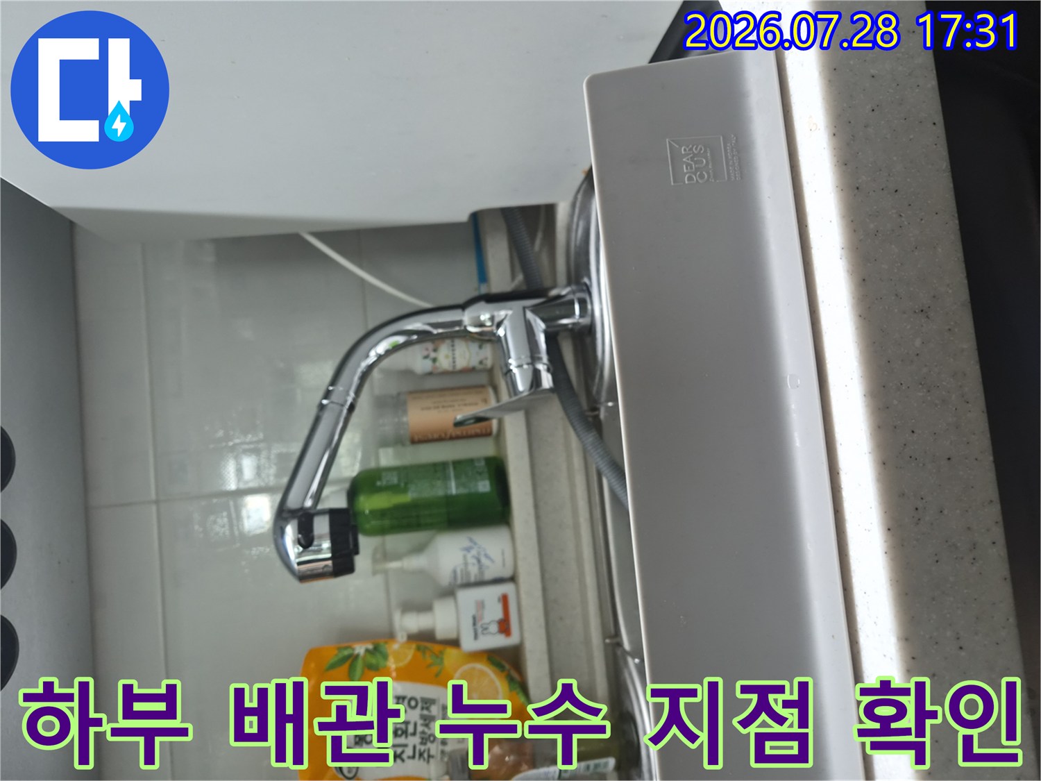 싱크대 하부의 식기세척기용 분리 밸브와 연결 호스 부위를 점검하는 사진