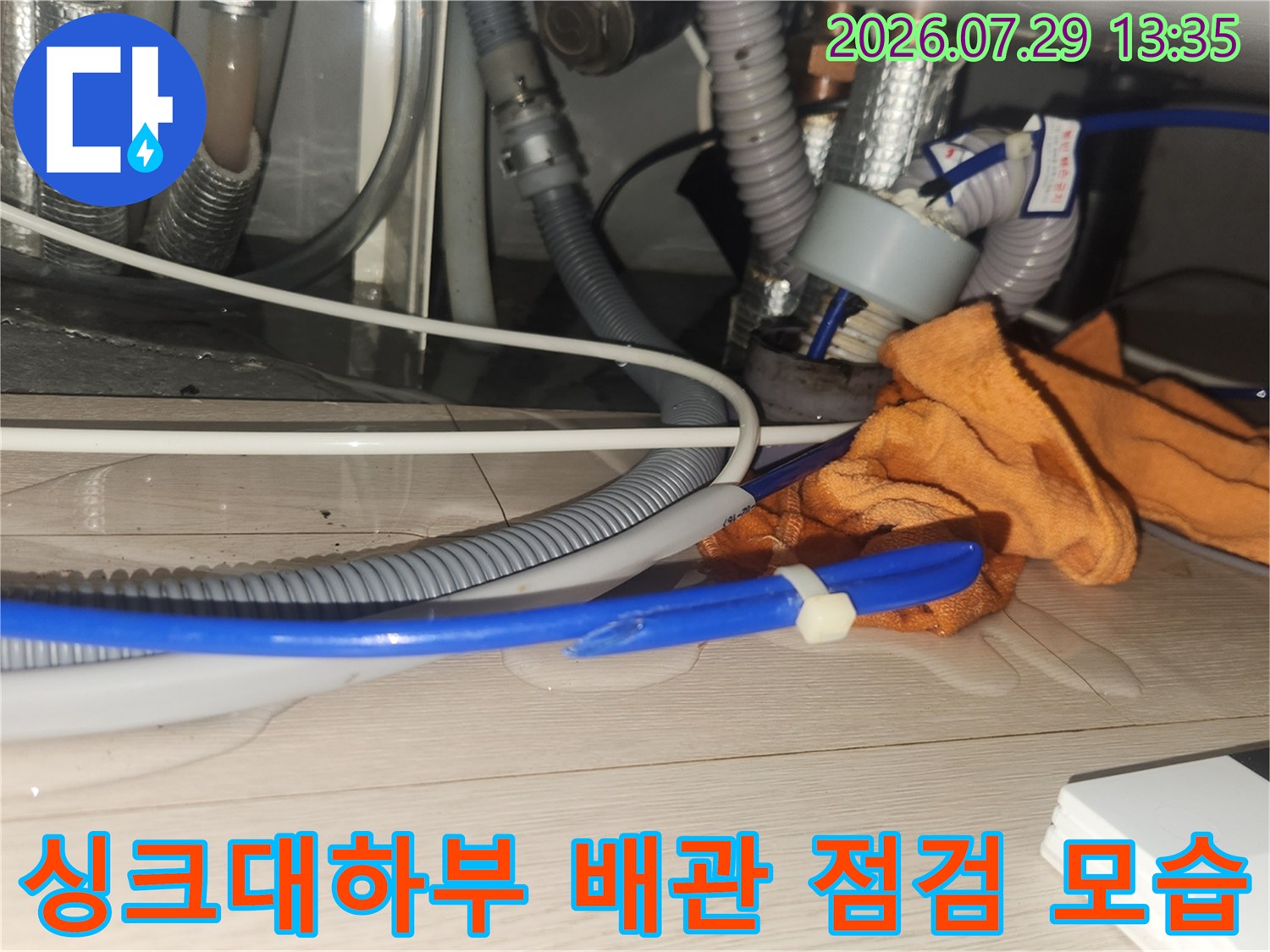 싱크대 하부에서 내시경 장비를 투입하여 배수관 내부를 정밀하게 검사하는 장면