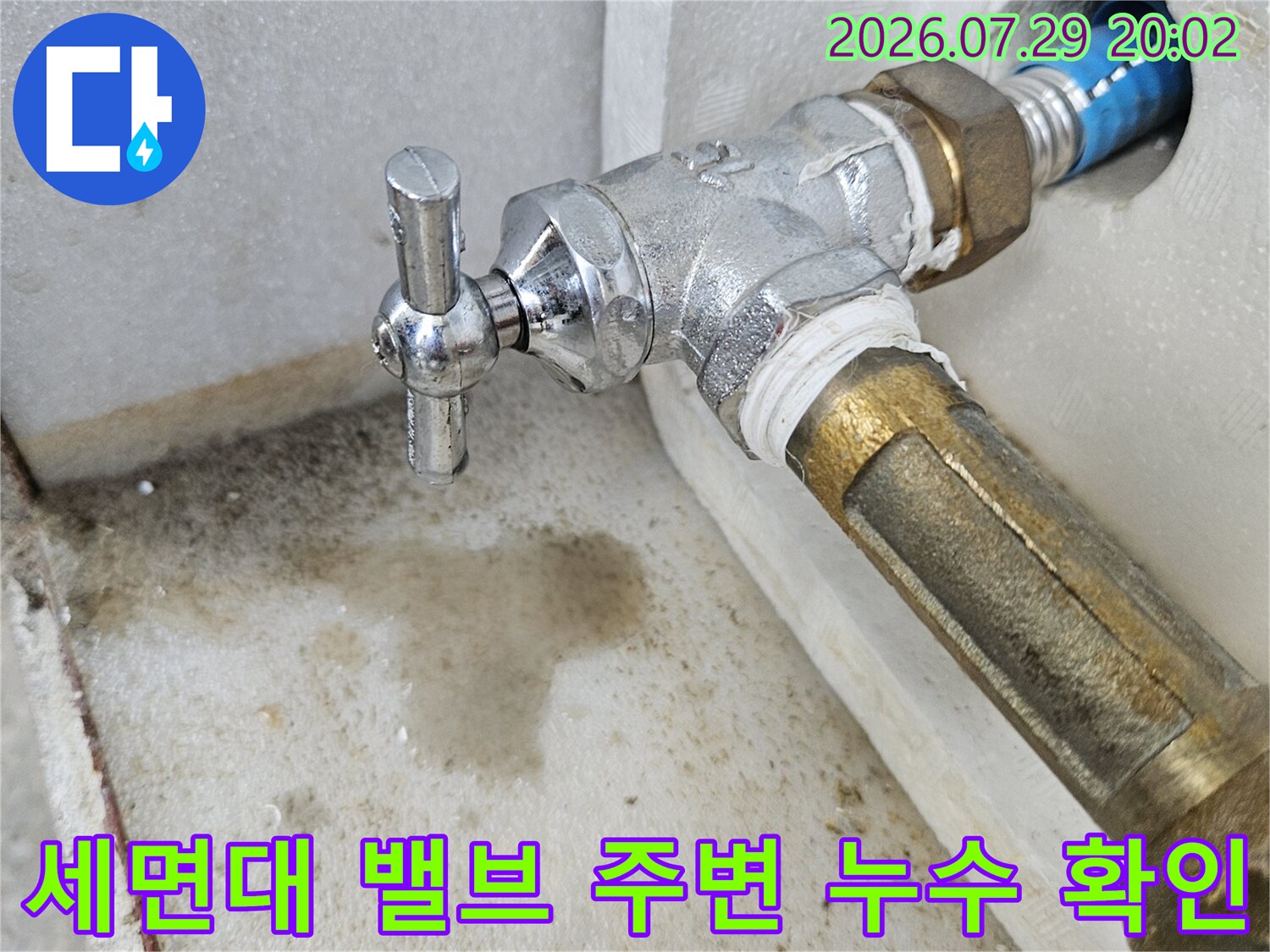 세면대 하단에 노출된 금속 배관과 급수 밸브의 연결 상태 촬영