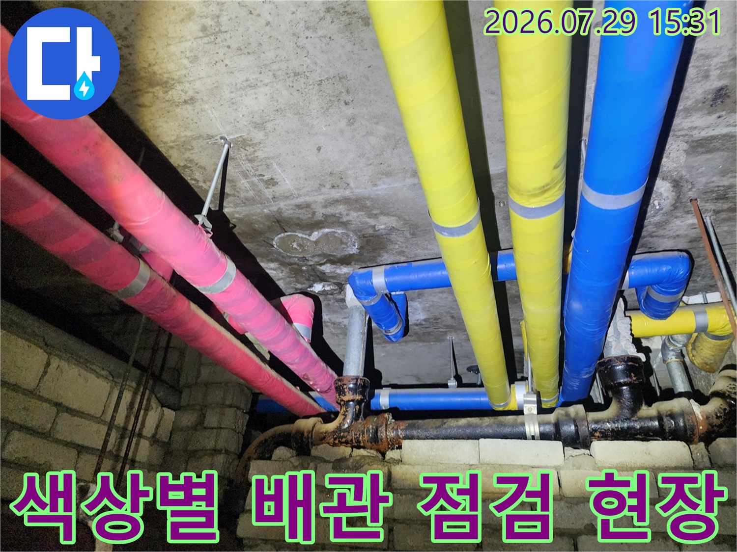분홍색과 노란색 및 파란색 보온재로 감싸인 상가 천장 배관 라인 점검 현장