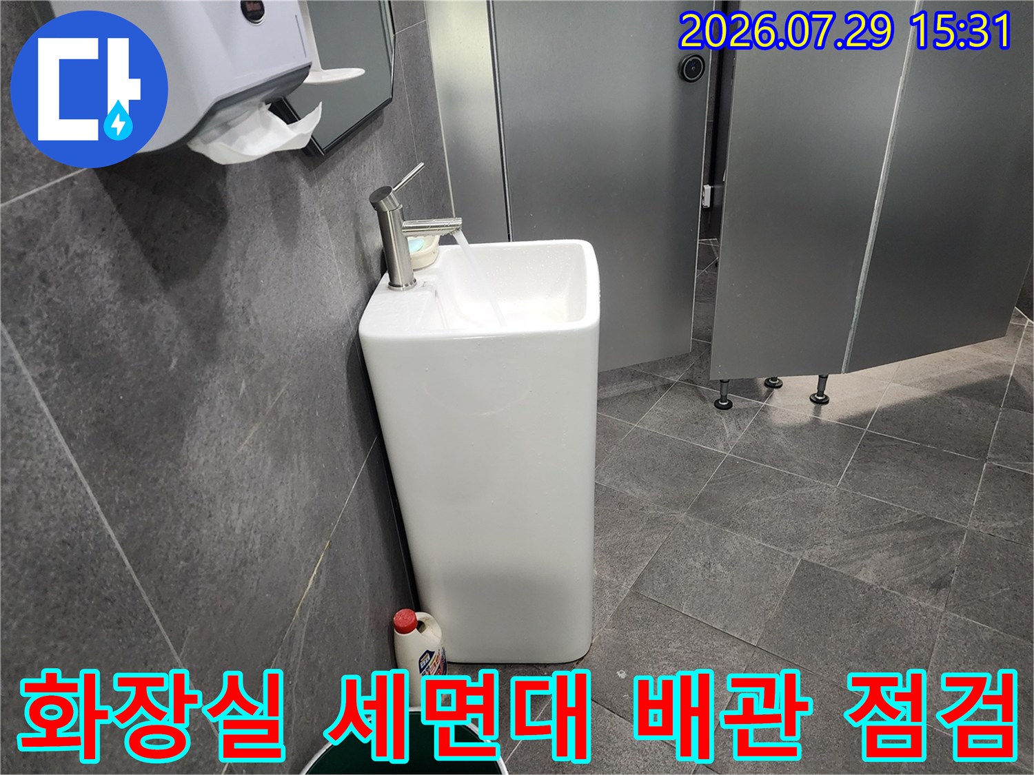 세면대 주변의 노출된 배관과 벽체 접합부를 조사하는 모습