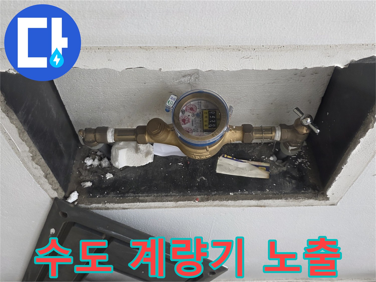 벽면 틈새에 설치된 수도 계량기와 금속 배관 구조물