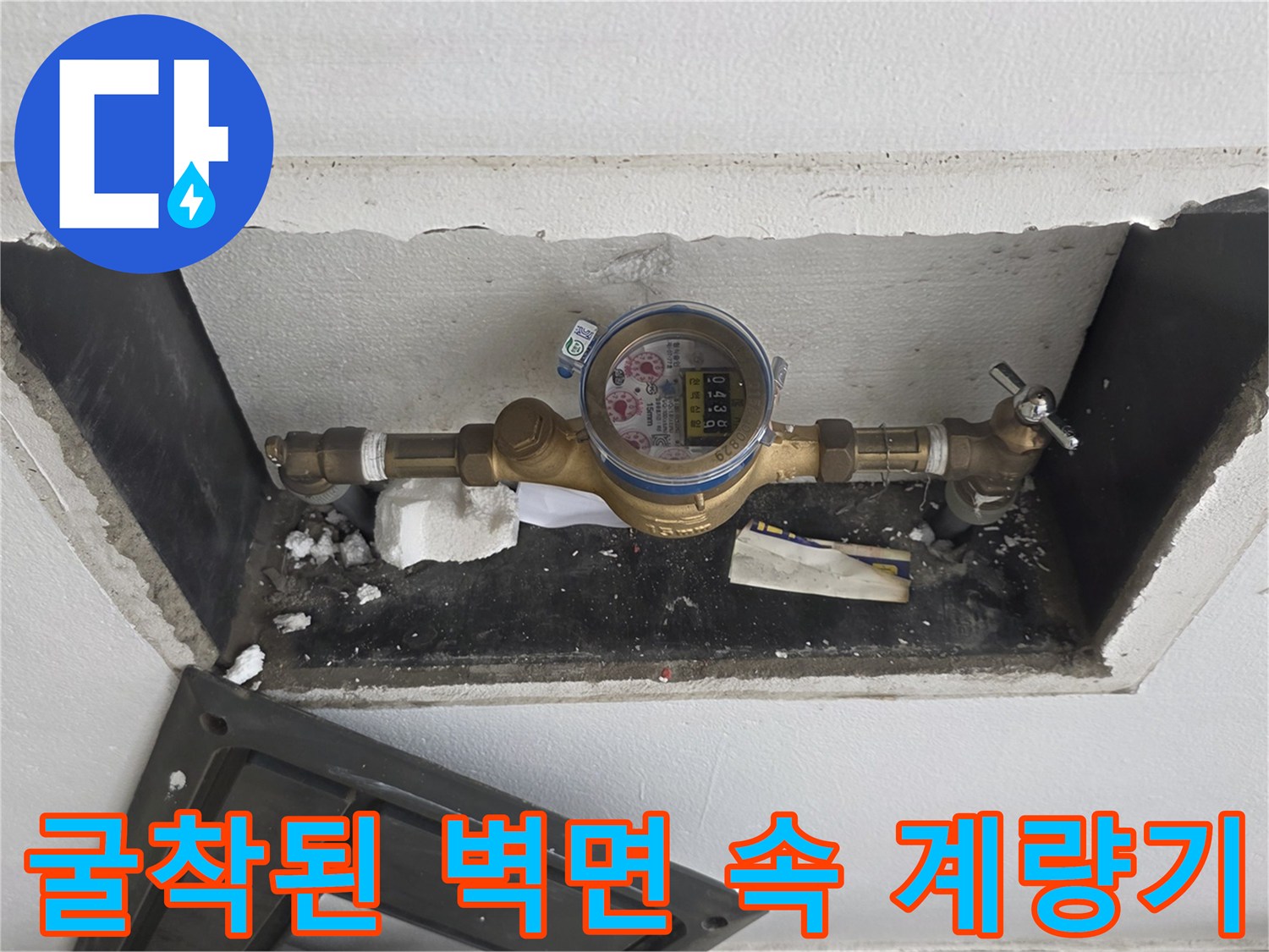 벽을 뚫어 노출시킨 수도 계량기와 밸브 장치