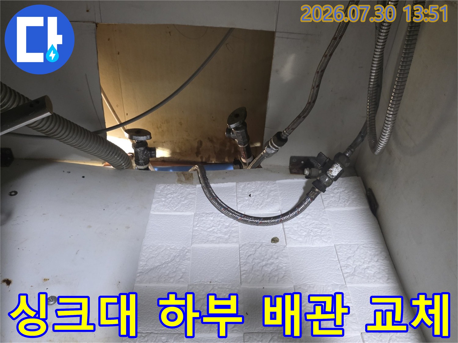 싱크대 하단부에 설치된 스테인리스 주름관과 급수 밸브 배관 연결 모습