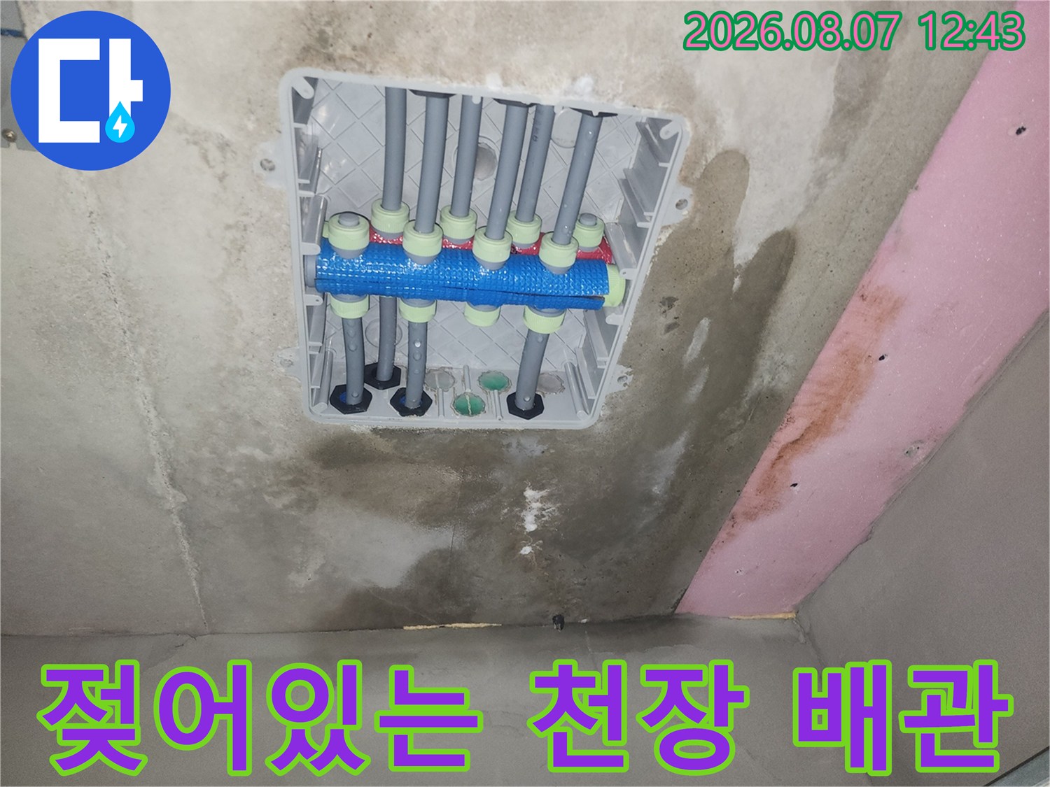천장 점검구 내부의 젖은 콘크리트와 배관 연결 부위