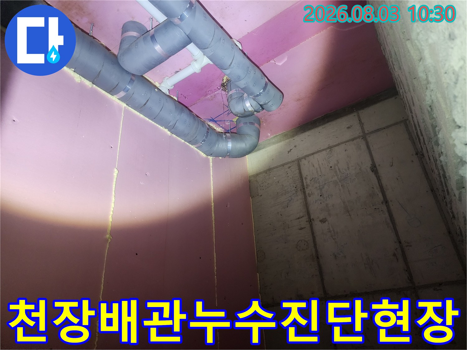 핑크색 천장 마감재 아래로 노출된 회색 배관과 연결 부위 점검 모습