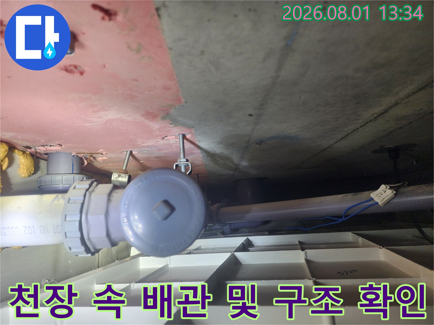상부층 화장실 천장 내부에 노출된 배관과 밸브를 점검하는 모습