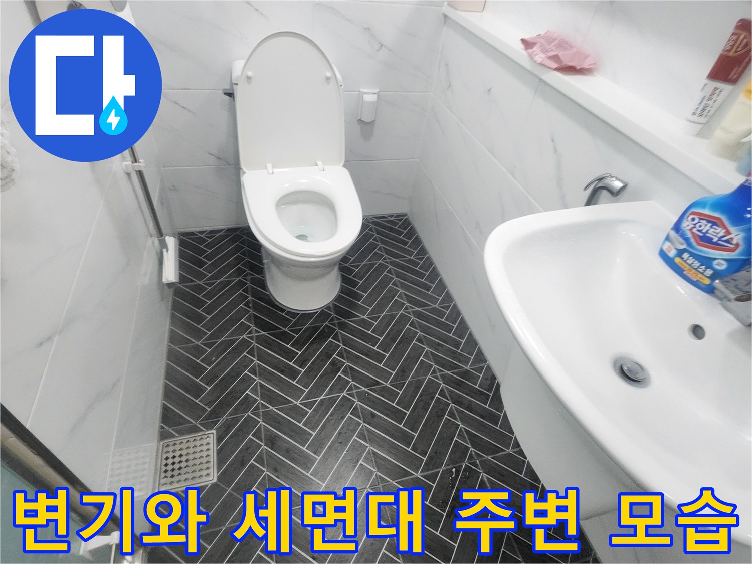세면대 아래쪽 변기 및 헤링본 타일의 깨끗한 시공 상태