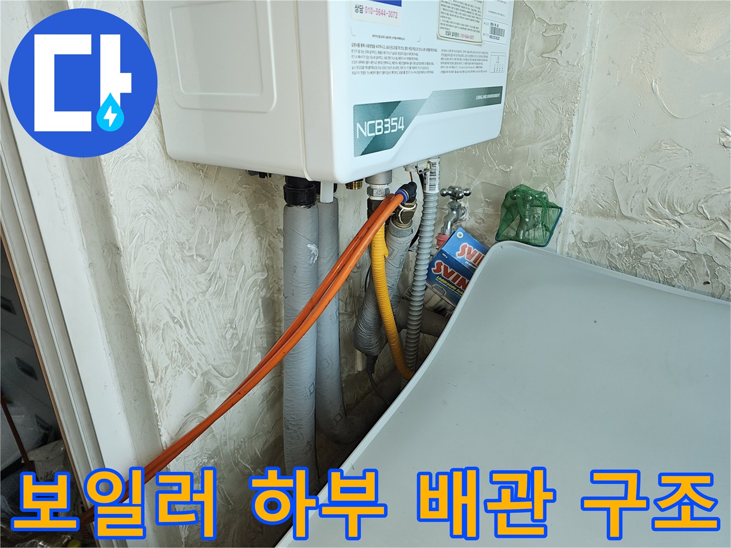 배관 점검 중-가스 탐지 호스가 연결된 보일러 아래쪽 모습