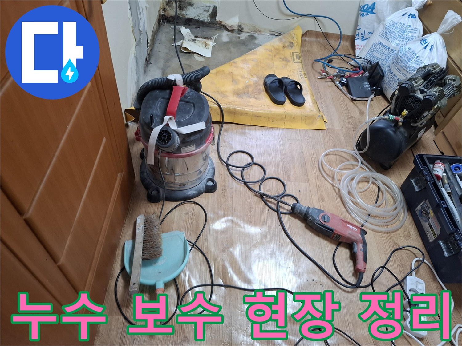 공사 장비와 청소 도구가-배치된 누수 수리 현장 바닥