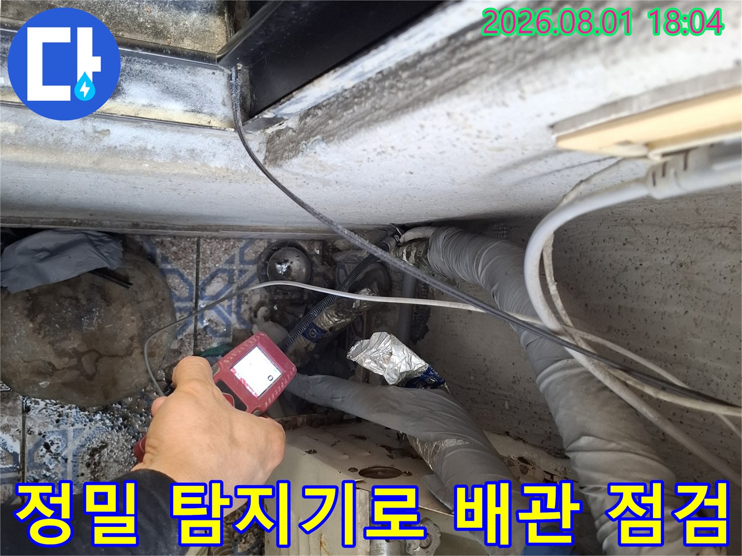 첨부된 사진 속 정밀 누수 탐지 장비를 사용하여 노출된 배관 부위를 세밀하게 점검하는 모습입니다.