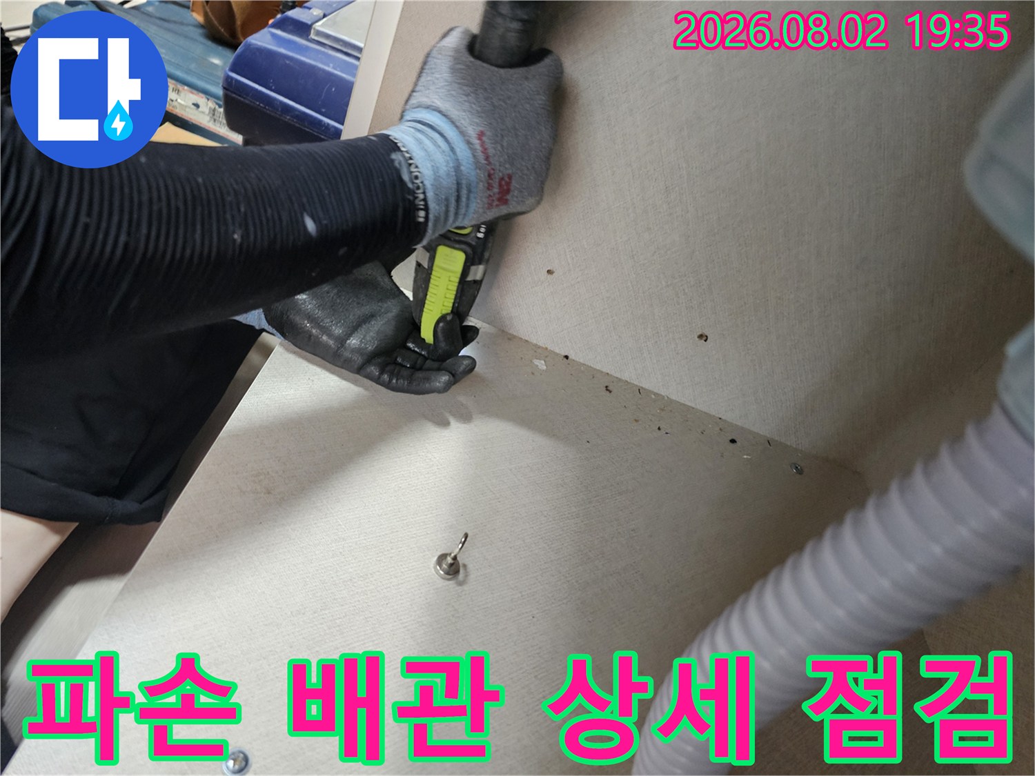 작업자가 파손된 수도 배관 연결 부위를 도구로 세밀하게 검사하는 사진