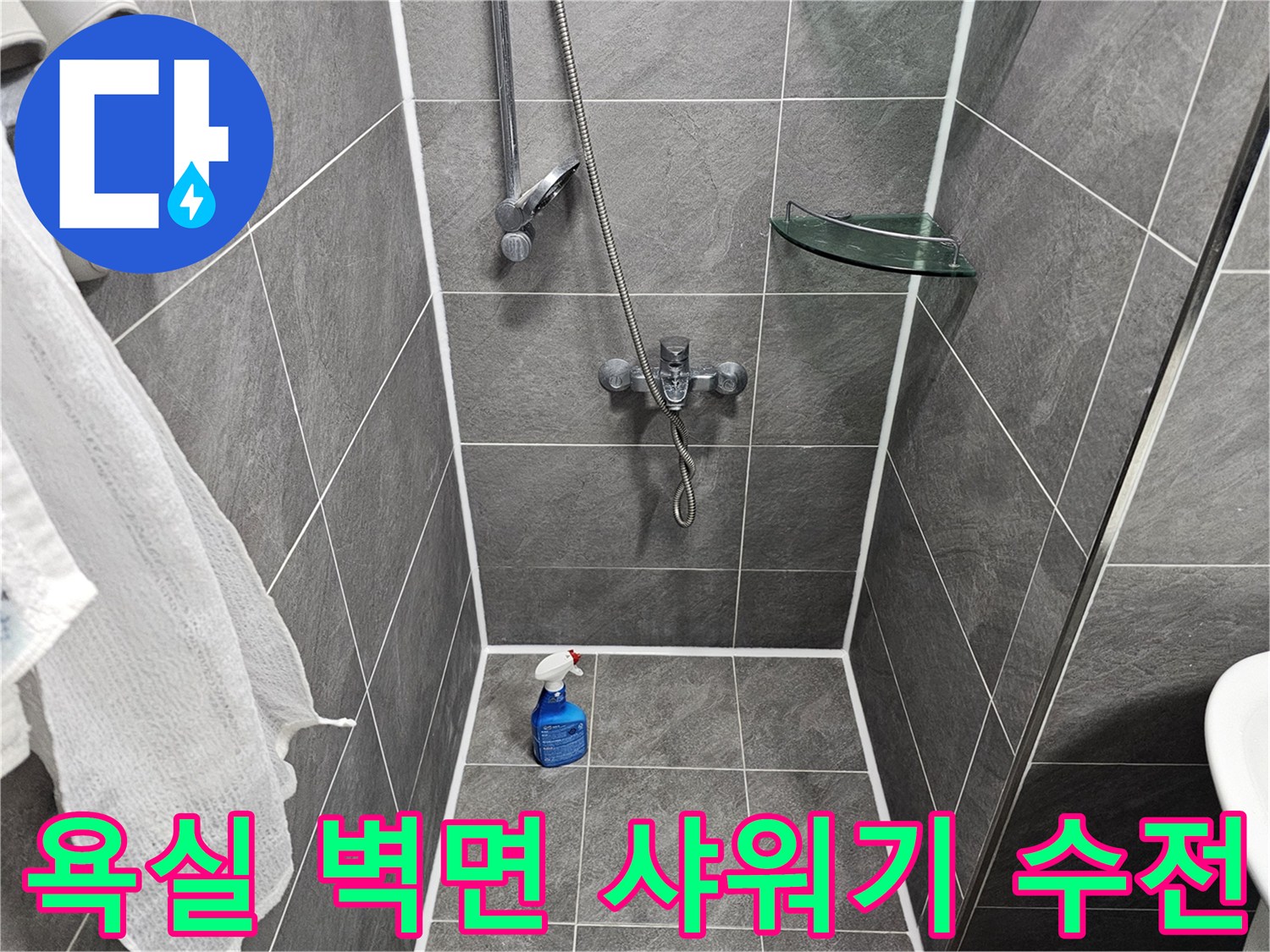 벽면에 설치된 은색 샤워기 수전과 타일