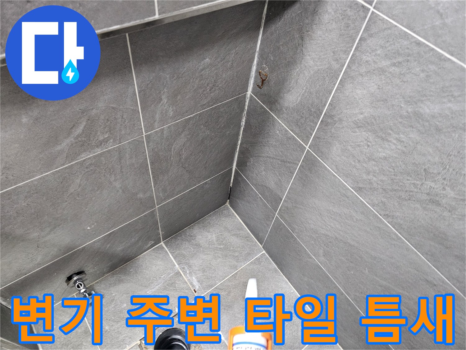 변기 하단 오수관 주변의 타일 틈새와 노출된 배관 상태