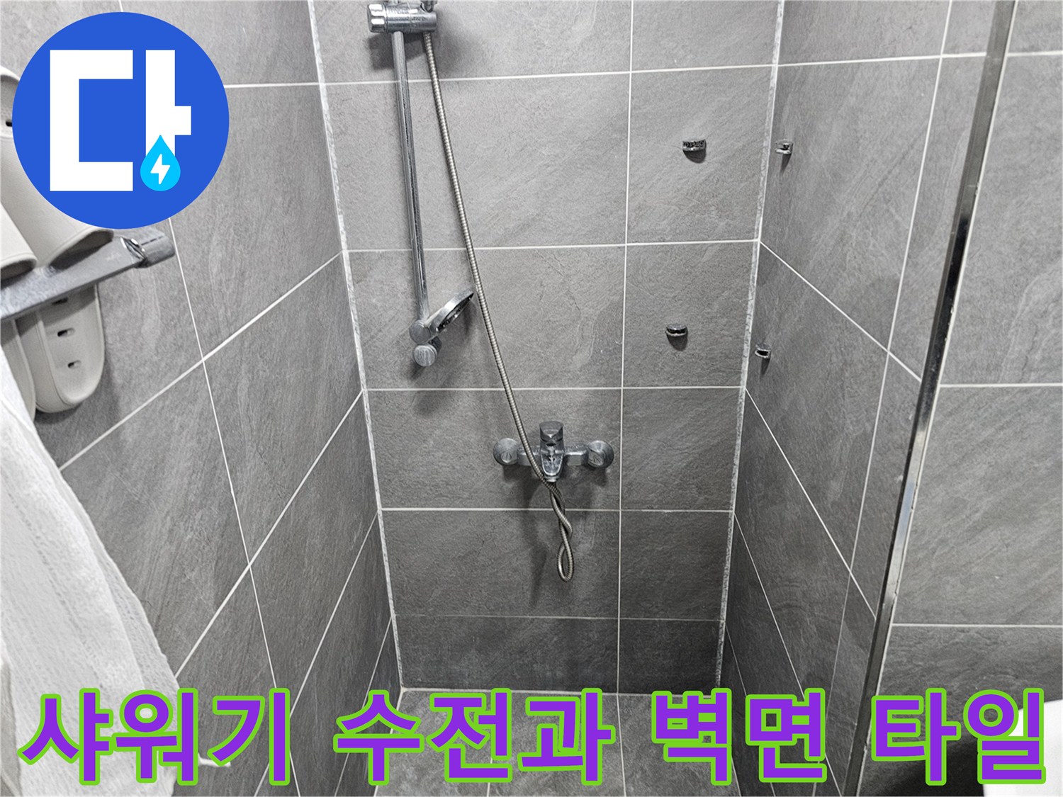 회색 타일이 시공된 샤워실의 수전 부위입니다.