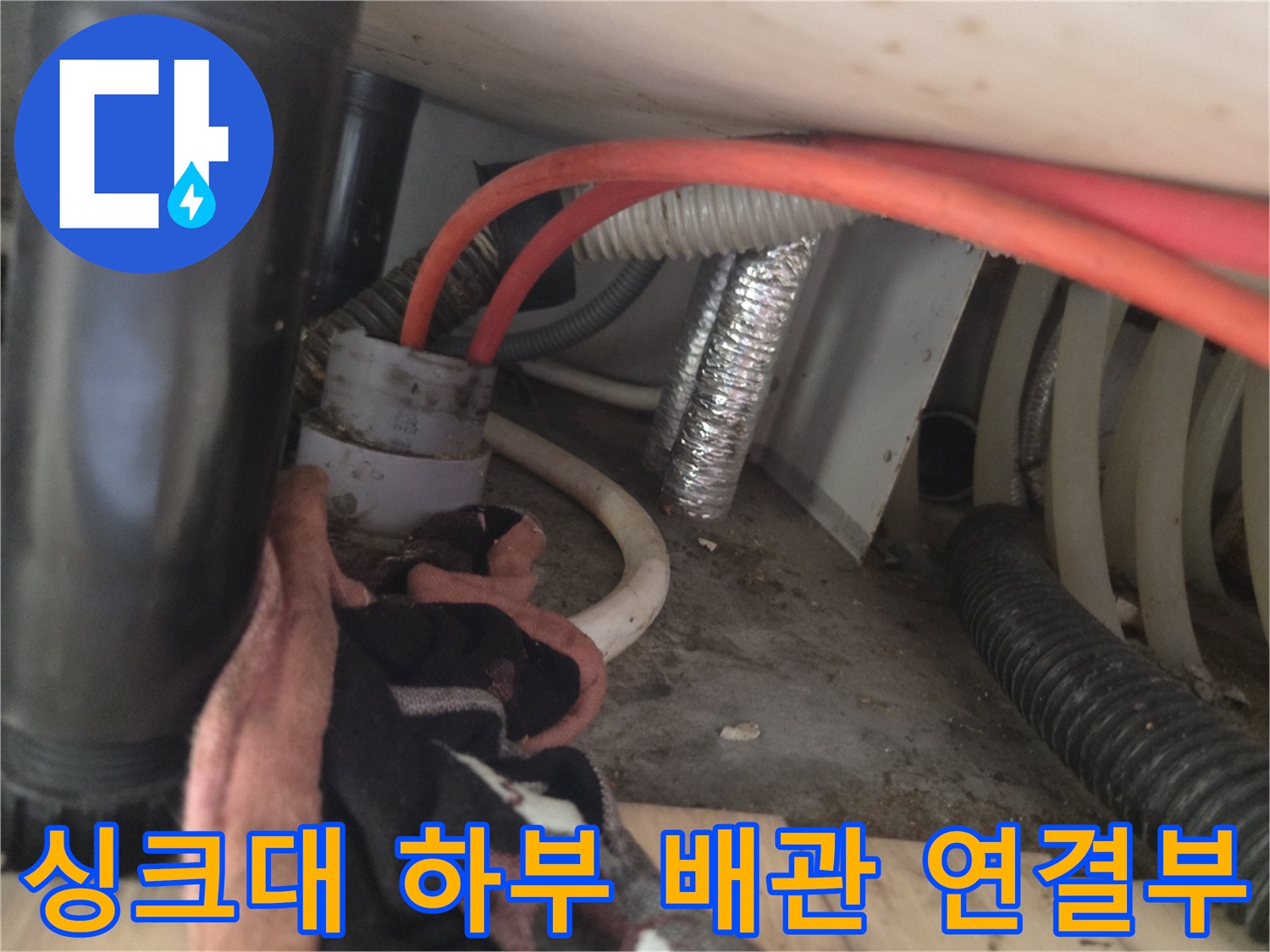 싱크대 아래쪽 호스와 배수관이 얽혀 있는 현장 사진