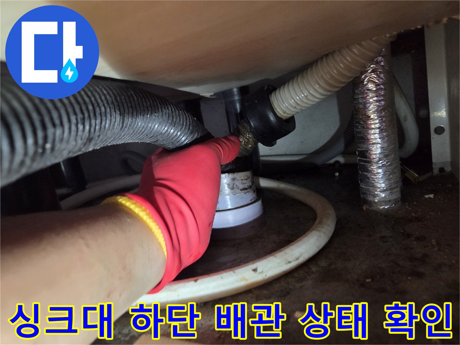 작업자가 싱크대 아래 배관 연결 부위를 점검하는 사진