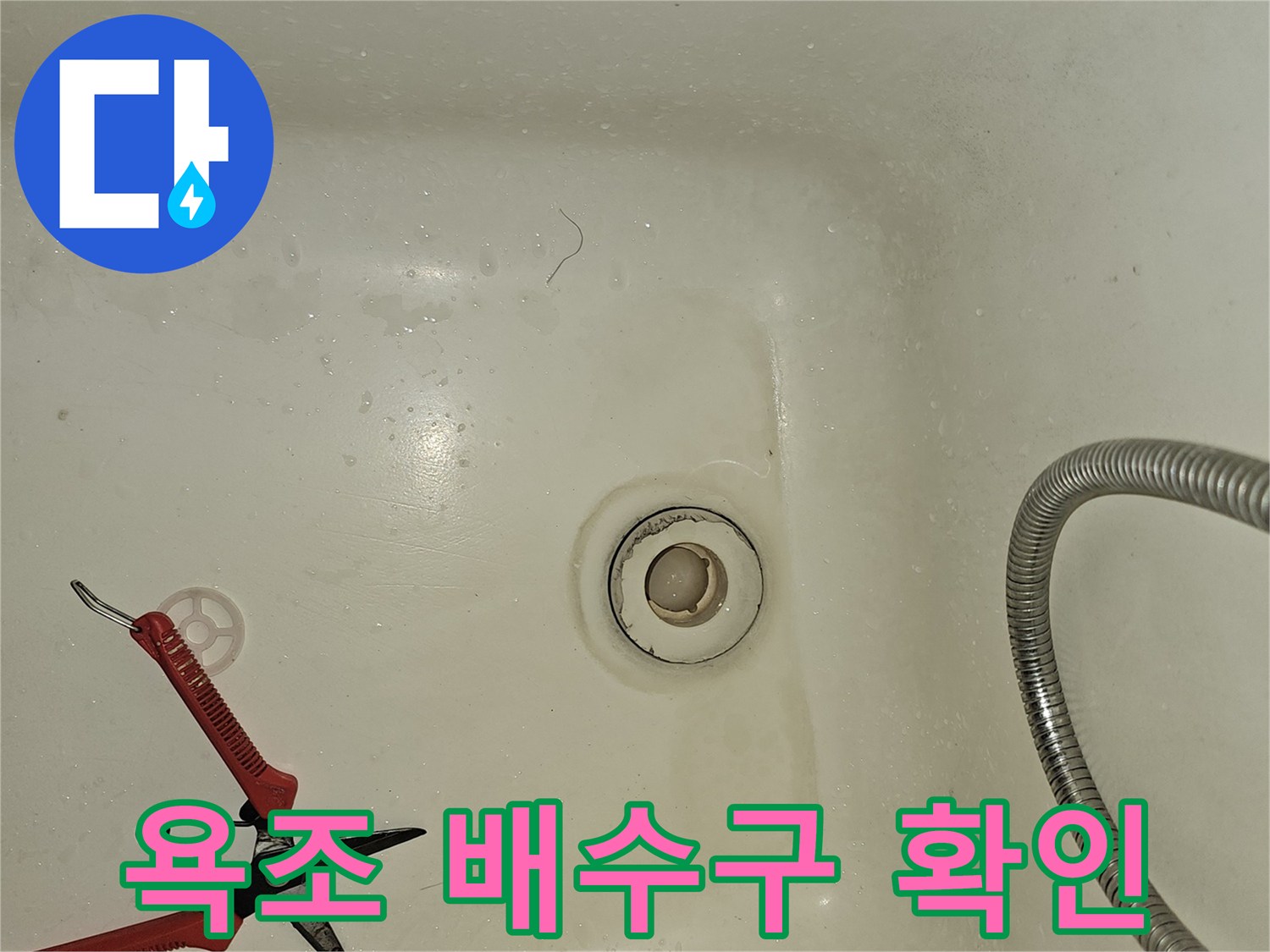 욕조 안쪽의 하얀색 배수구와 샤워기 줄