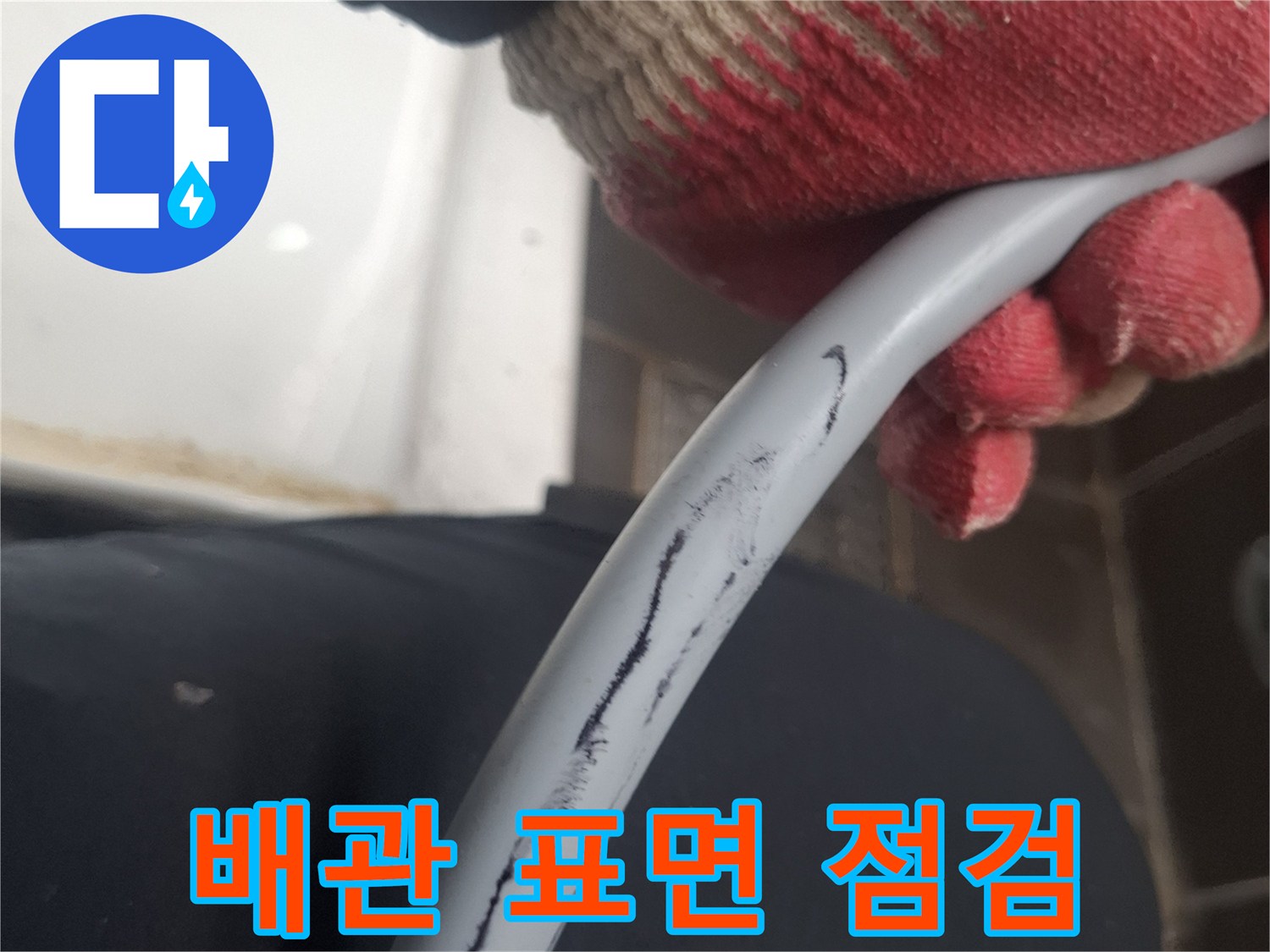 작업용 장갑을 낀 손이 배관을 잡고 있는 모습