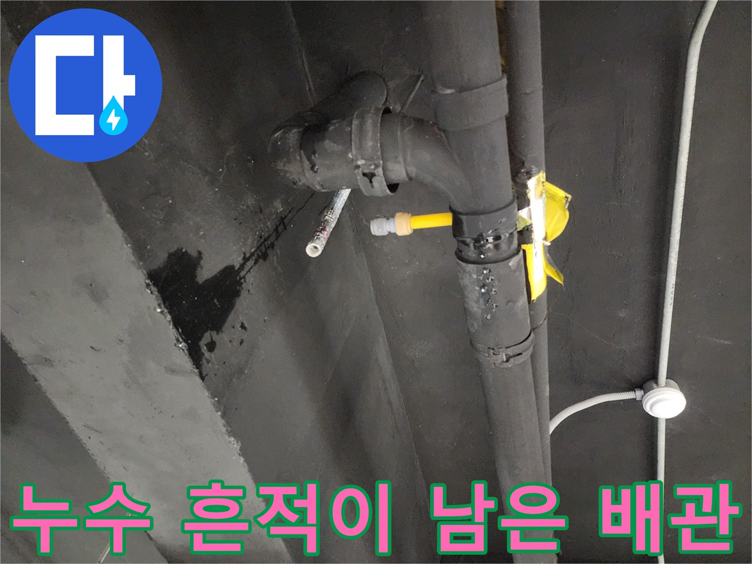 물이 새어 나와 검게 변한 배관 연결부와 벽면