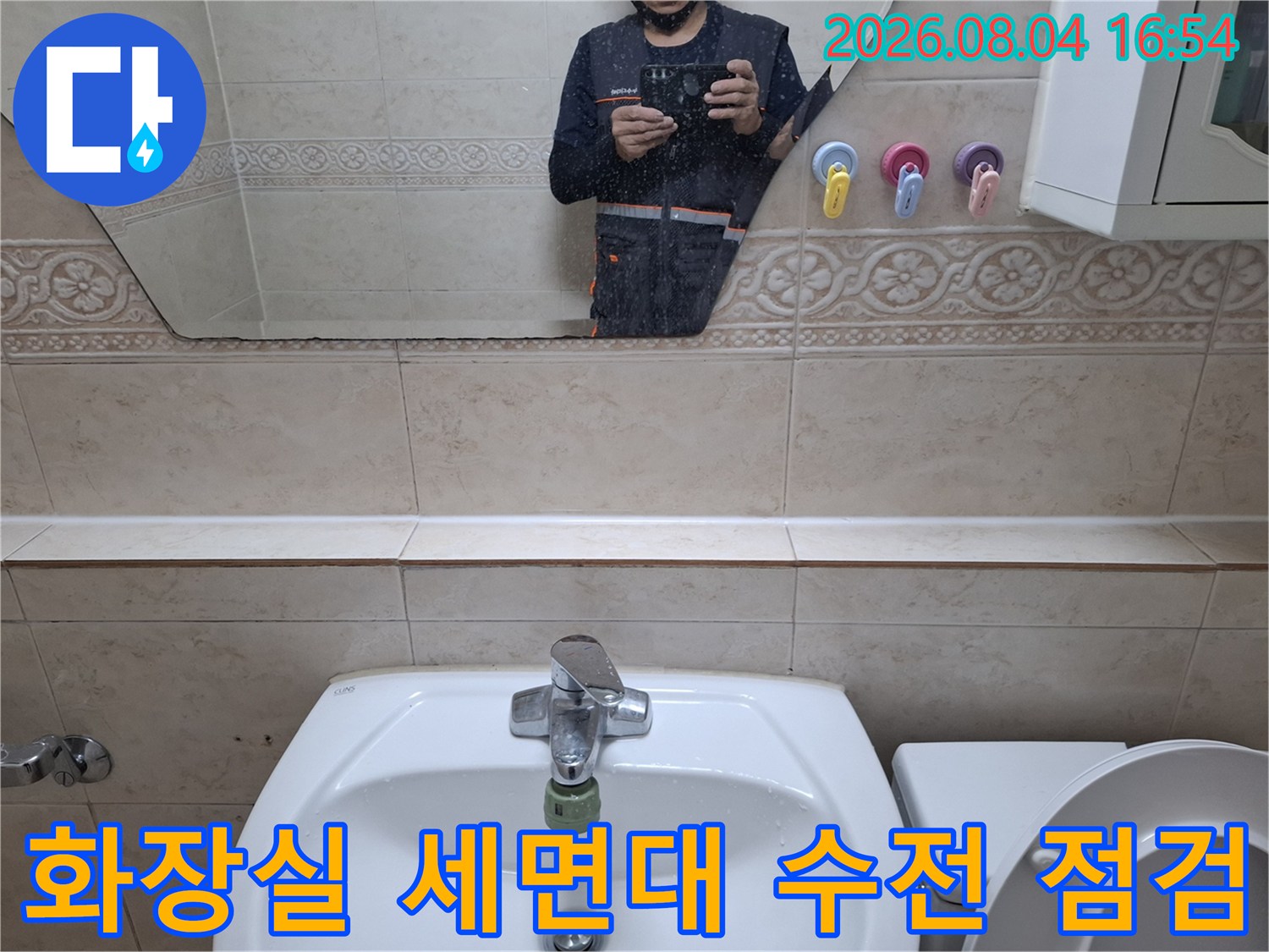 화장실 세면대에 설치된 수전과 주변 타일 마감 상태