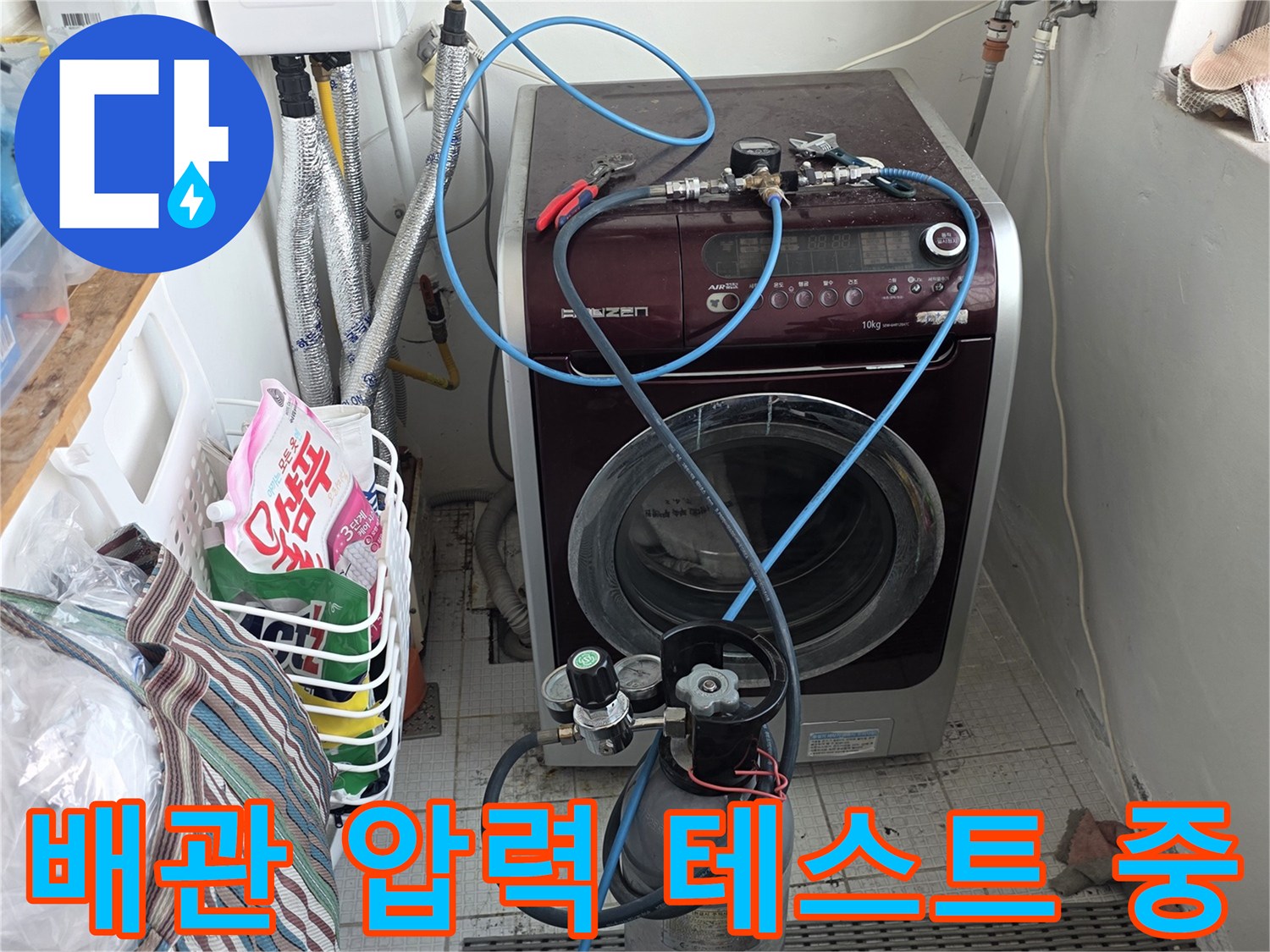세탁실 벽면 배관에 연결된 공압 측정 장치와 게이지