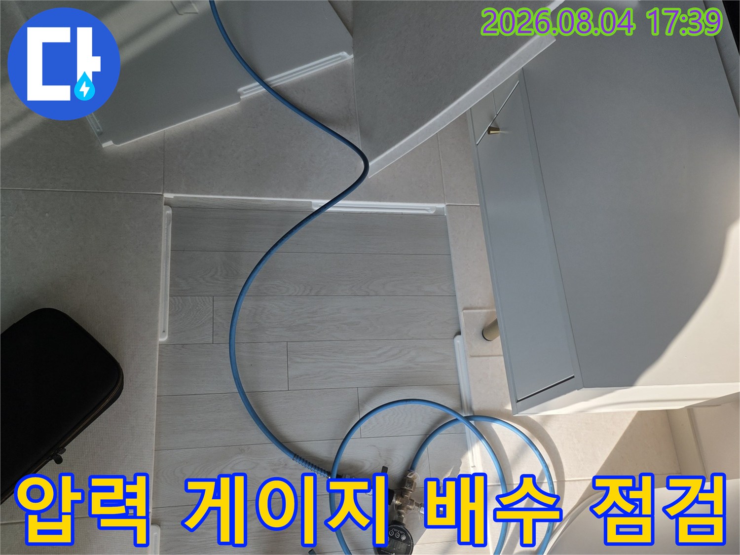 파란색 측정용 호스를 연결하여 에어컨 배출 경로의 수압 및 흐름을 확인하는 전문 장비 세팅.