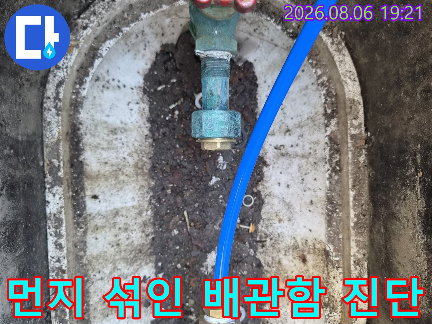 오염된 환경 속에서도 파란색 수도 배관과 부속의 누수 여부를 면밀히 확인하는 모습