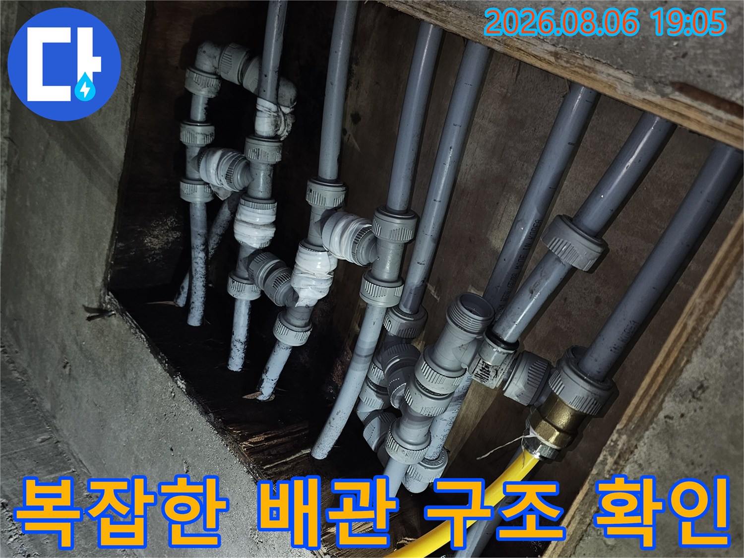 천장 내부의 복잡하게 얽힌 급수 배관 시스템 점검