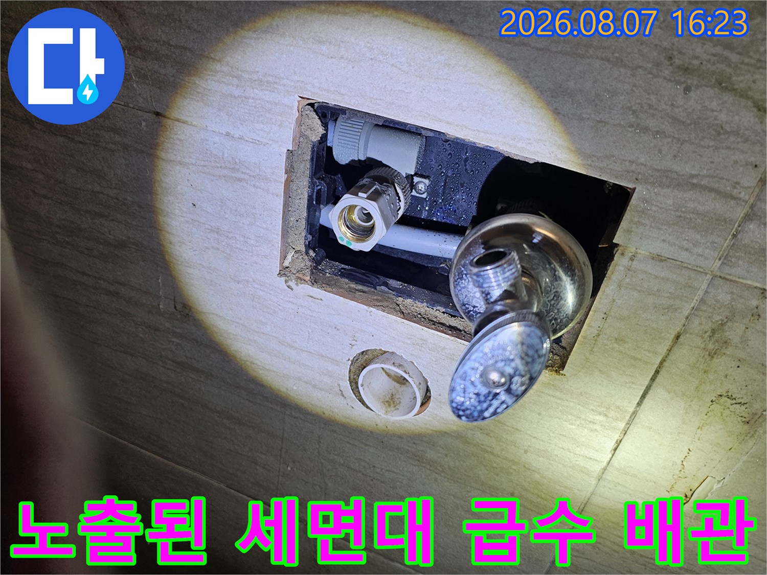 세면대 하단 타일 제거 후 노출된 회색 매립 배관과 수전 연결부