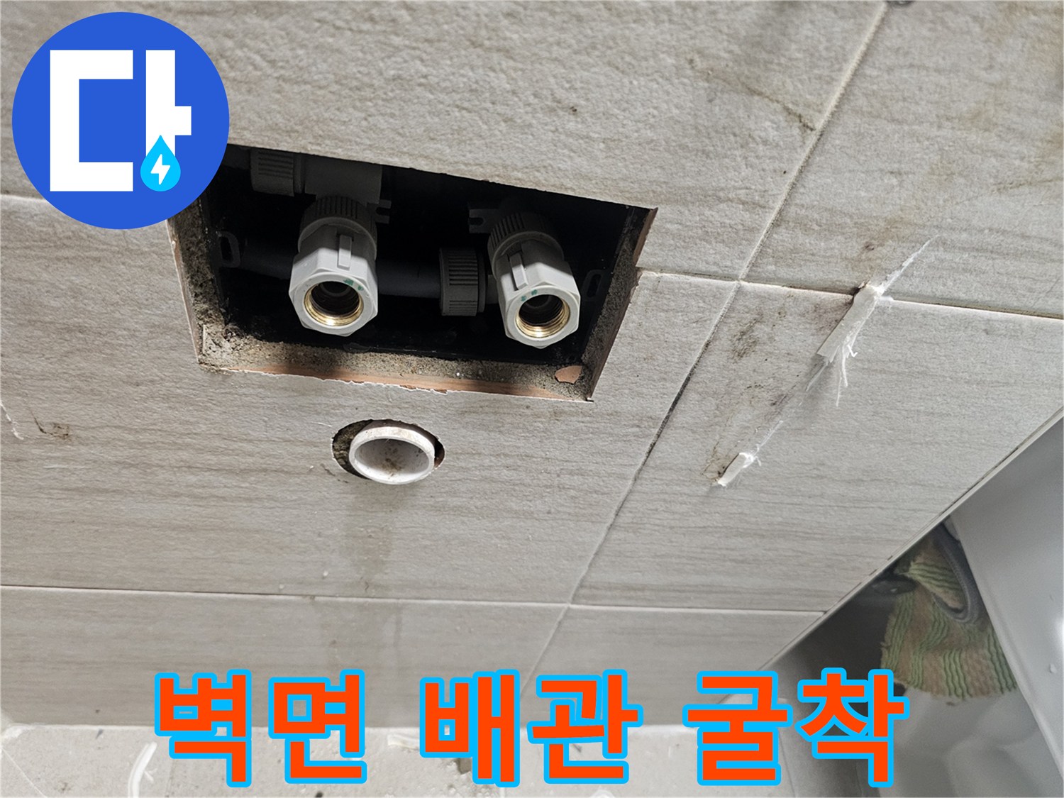 타일 틈 사이로 보이는 파손된 급수 배관 부속