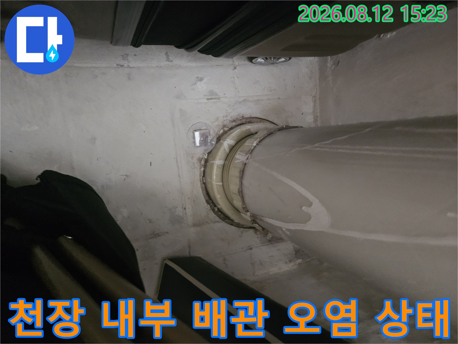하얀색 배관이 천장을 관통하는 부위에 발생한 누수 얼룩과 습기 사진