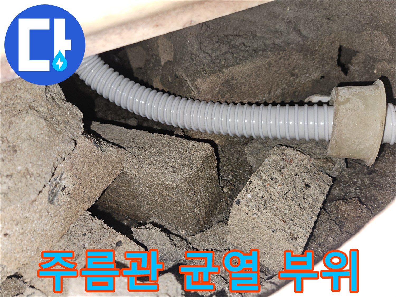 콘크리트 틈 사이로 노출된 파손된 흰색 주름관