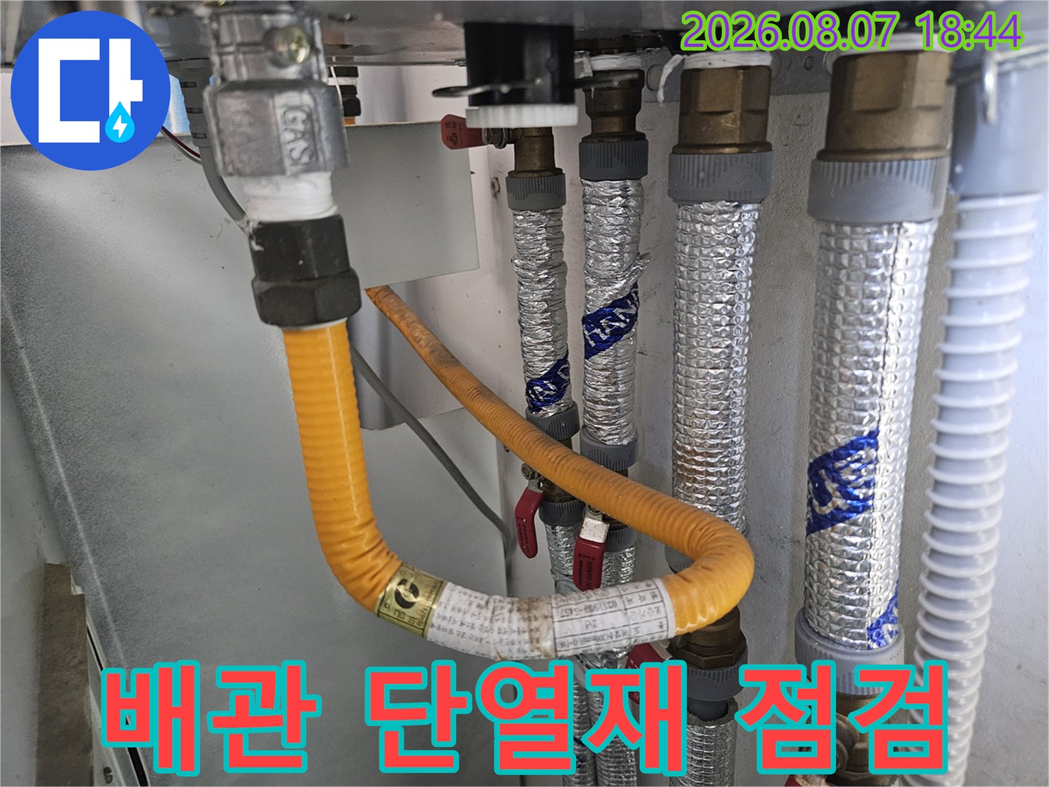 은박 단열재로 감싸진 배관과 노란색 보온재가 연결된 모습입니다.