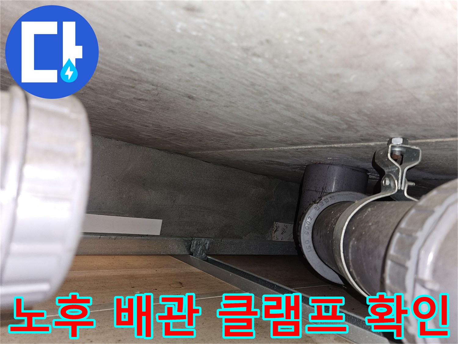 천장 구조물에 고정된 배관 연결 부위 근접 촬영