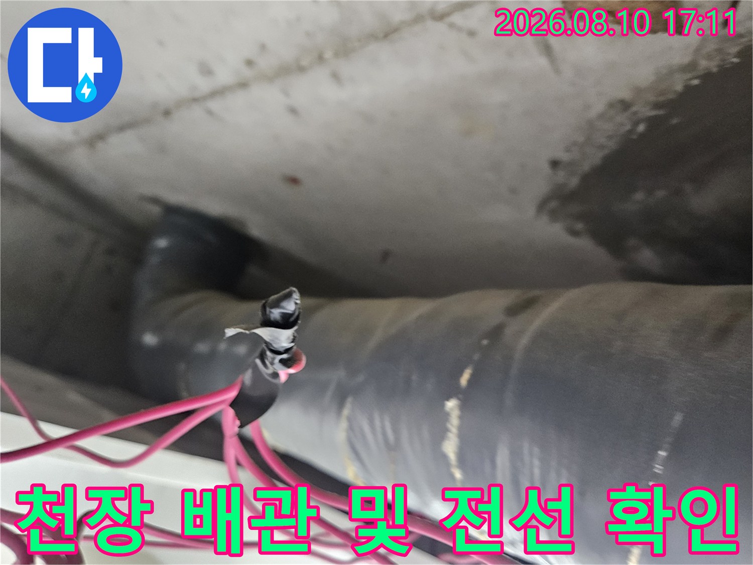 아파트 화장실 천장 내부-노후된 배관과 붉은색 전선의 근접 촬영