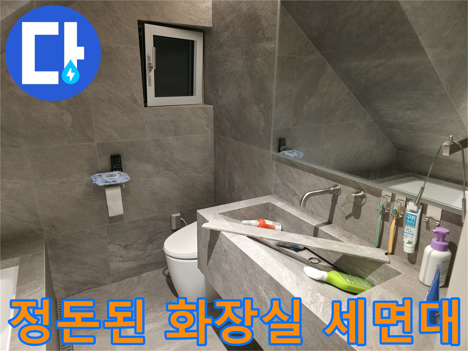 그레이 타일 벽면과 일체형으로 제작된 세면대 공간
