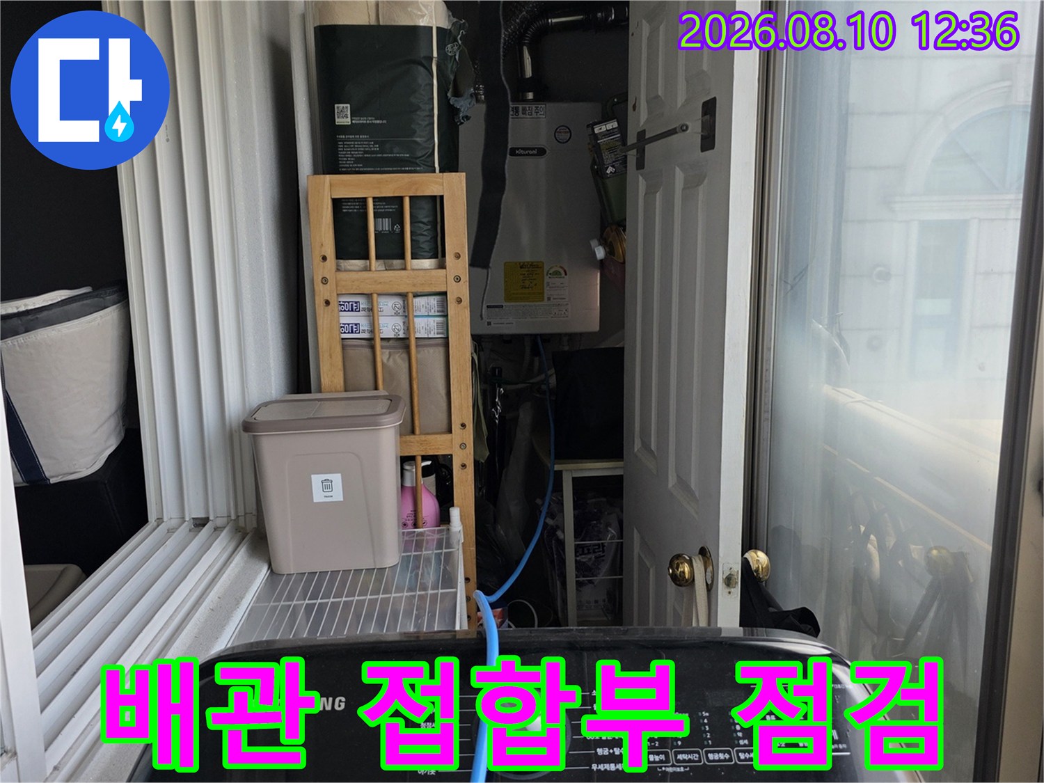 아파트 베란다 내부의 수전과 배관이 연결된 부위를 근접 촬영한 사진입니다.