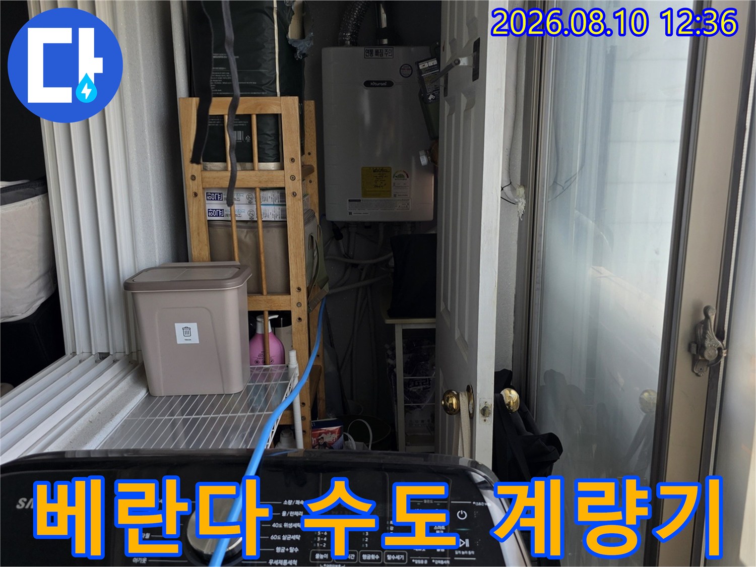 아파트 베란다에 위치한 수도 계량기와 배관 설비입니다.