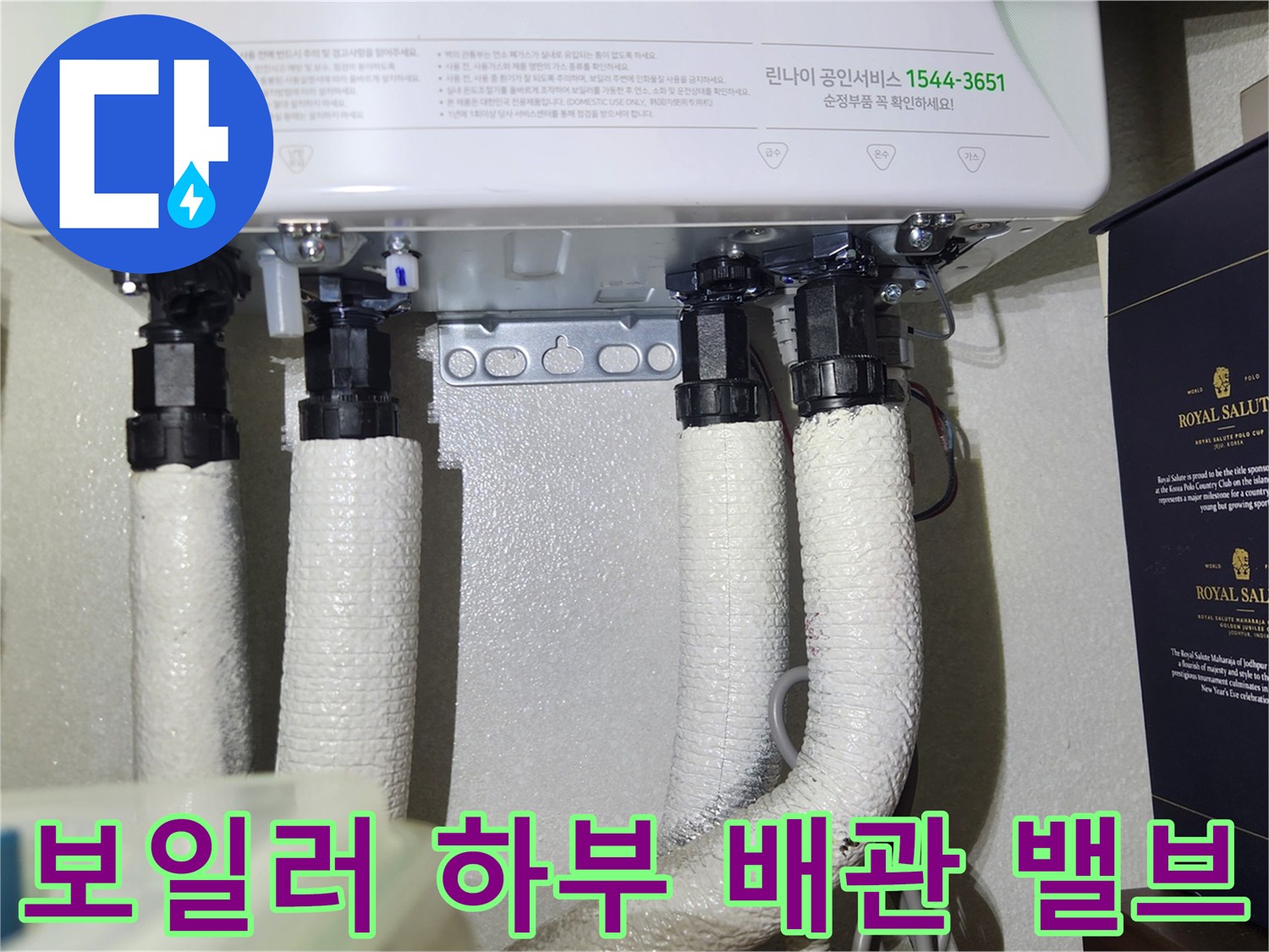 보일러 본체 아래로 연결된 배관과 밸브의 근접 사진입니다.